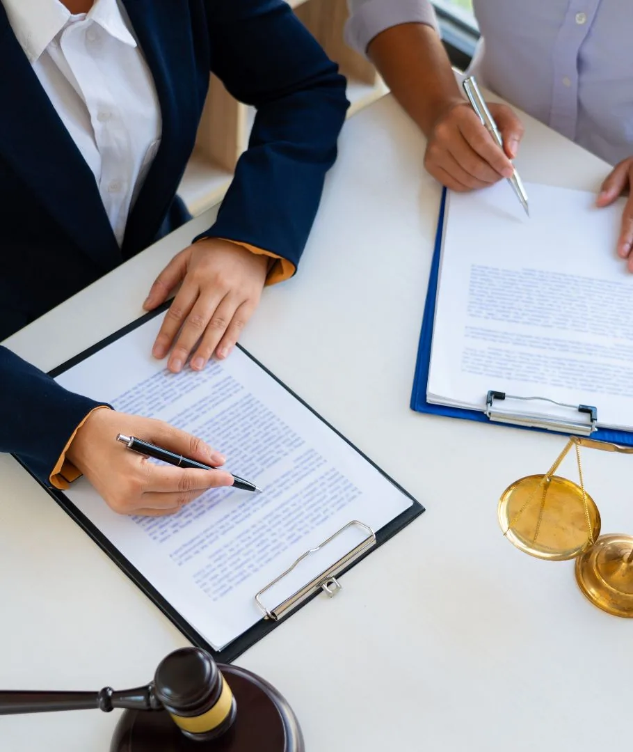 Firma de documentos legales con balanza y mazo de juez
