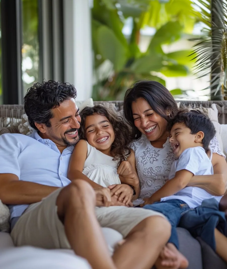 Familia riendo junta en un sofa en casa