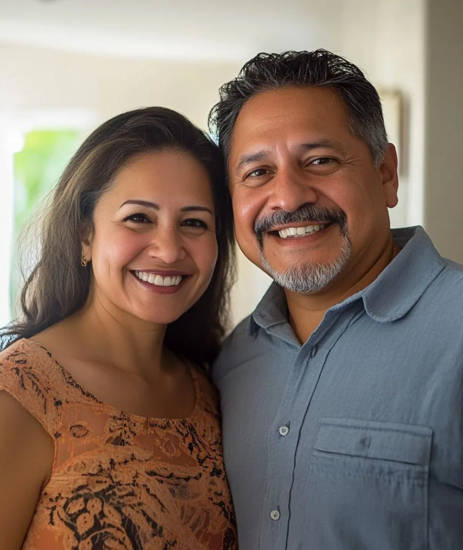 Pareja hispana sonriendo mientras planifican su patrimonio